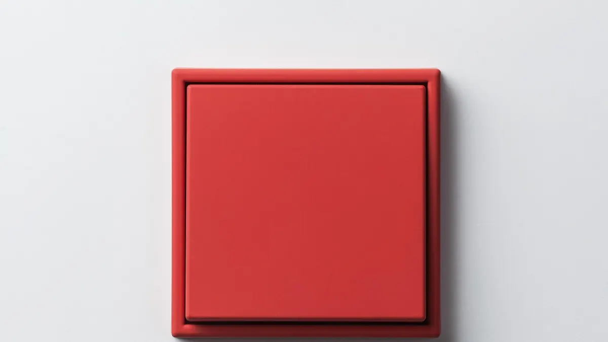 Interruptor de parede vermelho em superfície branca limpa
