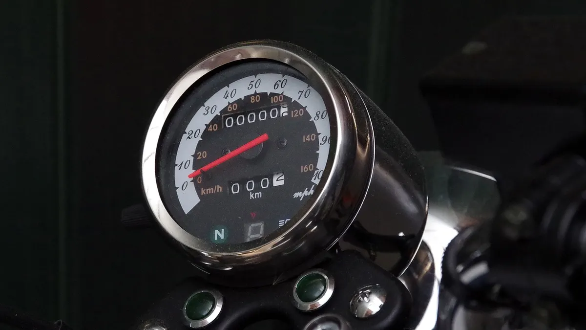 Painel de moto com velocímetro redondo e luzes indicadoras